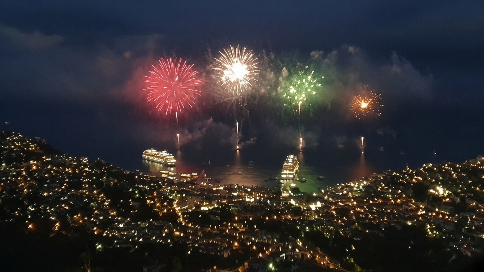 Fireworks burst over Funchal bay at night above the lit hillside city and two cruise ships