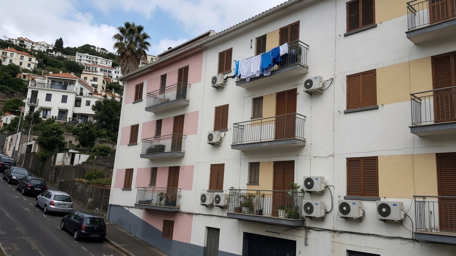 An ordinary Funchal apartment block with shutters, balconies, laundry and air-conditioning units