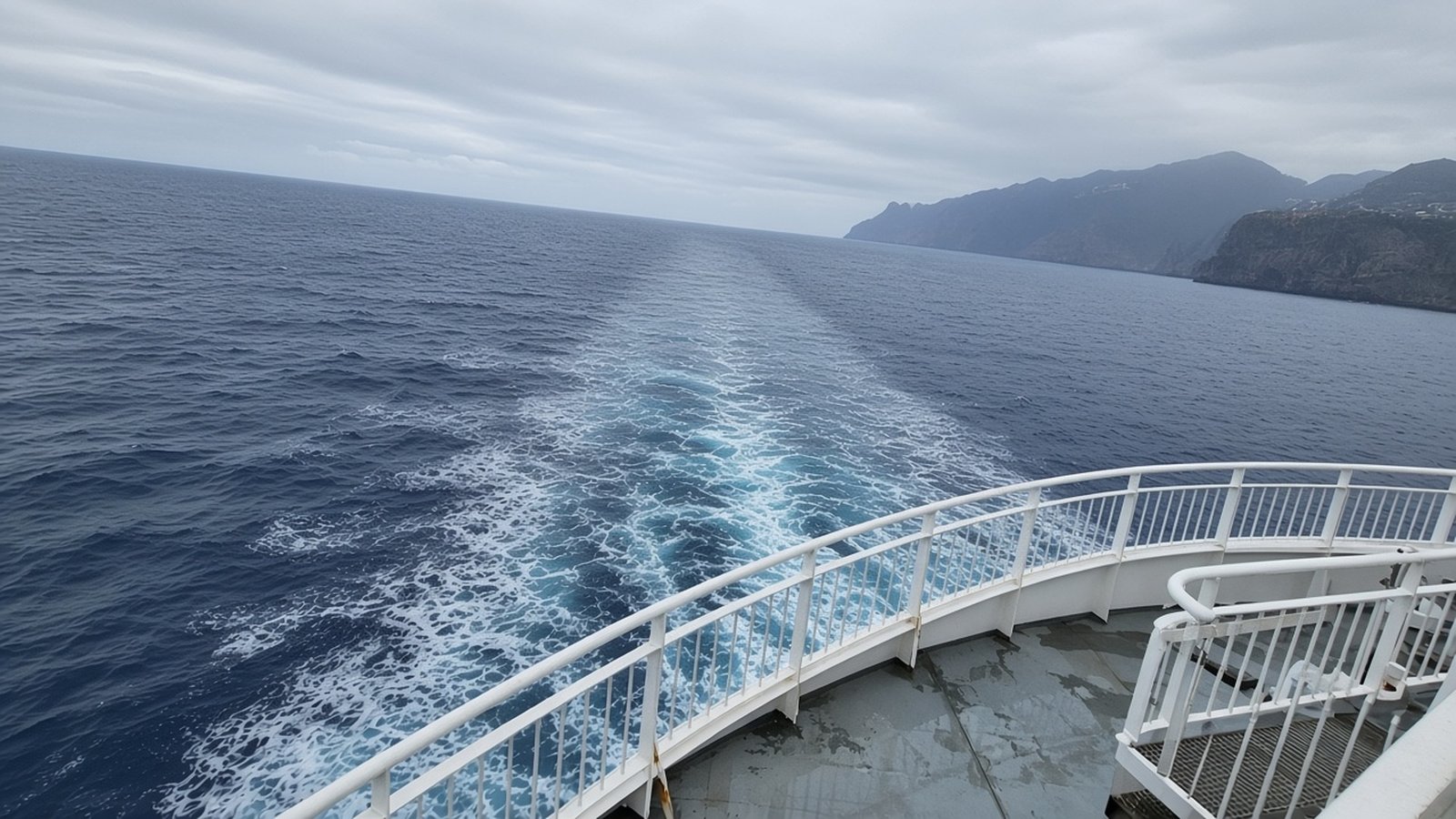 The foaming wake behind a ferry's rear deck, with Madeira's mountainous coast fading behind